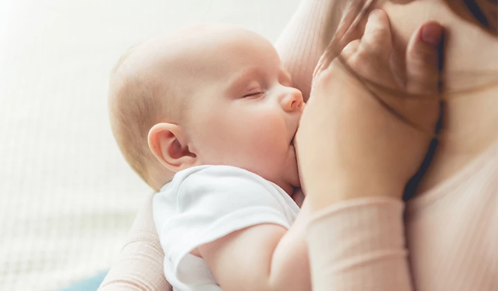 Frau stillt Baby  Darmflora aufbauen: Kind stillen